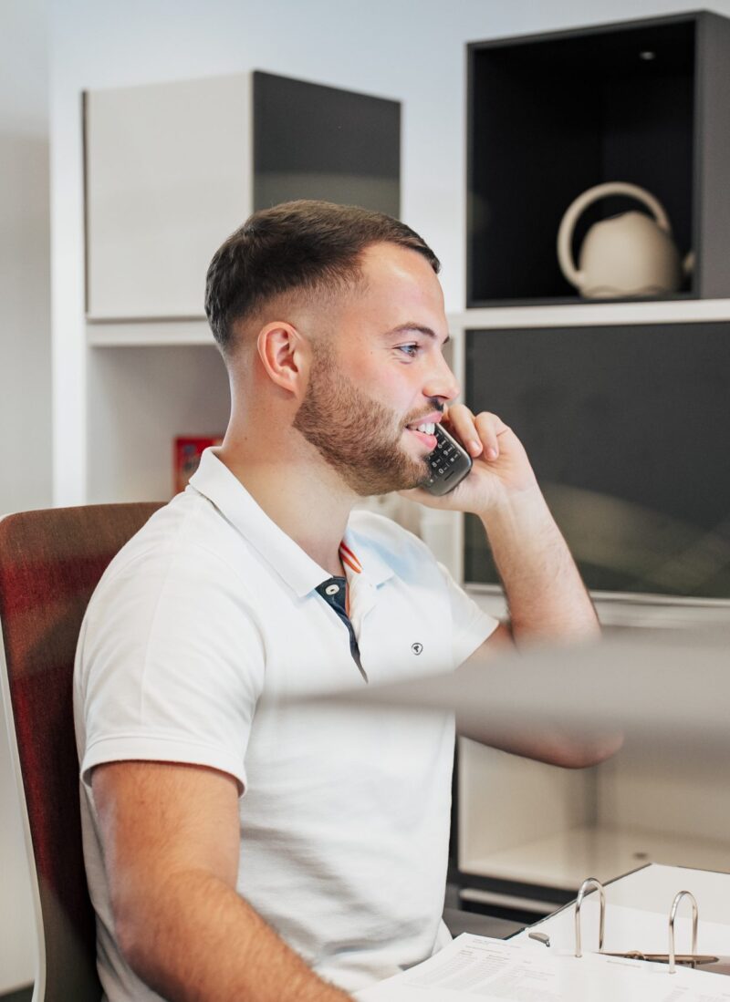 Junger Mann am Empfang mit Telefon